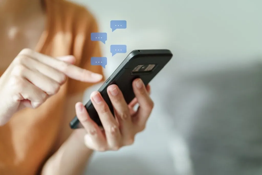 Mensch interagiert über sein Handy mit anderen Leuten