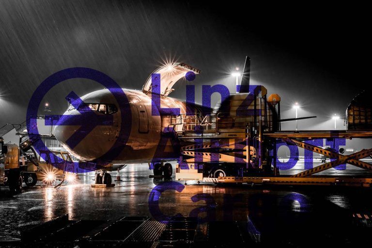 Nachtaufnahme einer Frachtmaschine bei Regen, beladen am Linz Airport Cargo Terminal.
