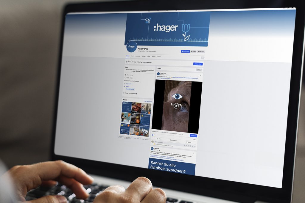 Person arbeitet am Laptop mit geöffneter Facebook-Seite von Hager Austria, sichtbar ist ein Reel-Post.