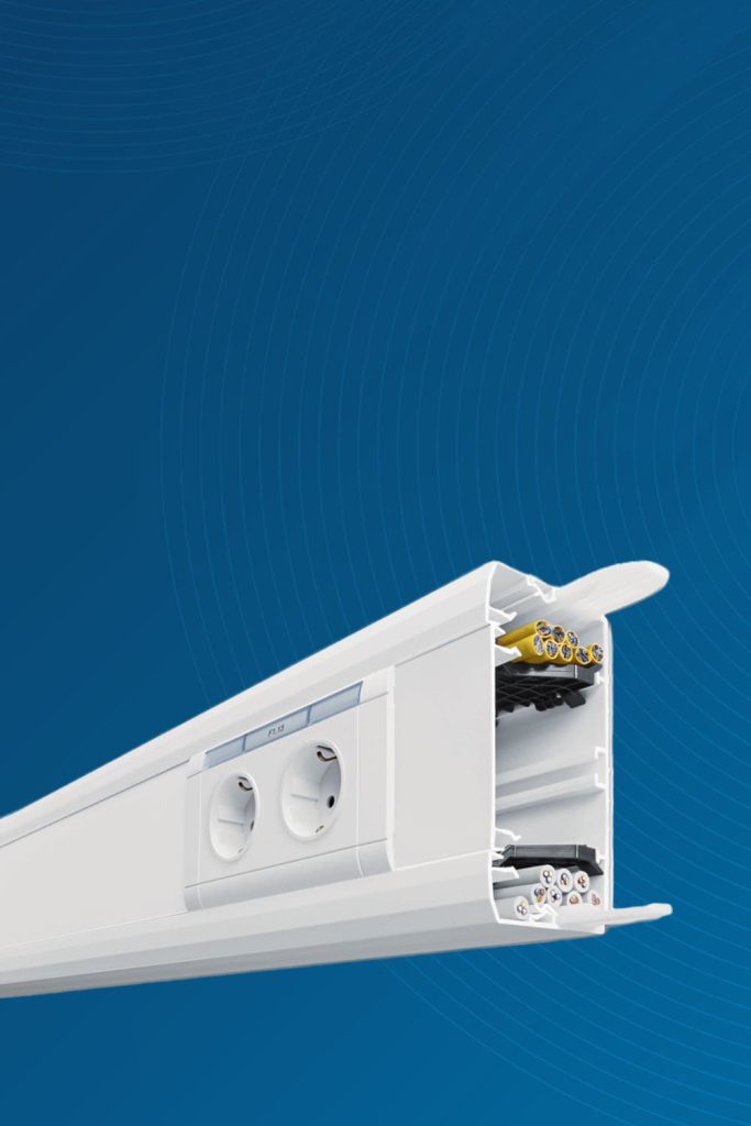 Weiße Elektroinstallationsleiste mit Steckdosen und Kabeln vor blauem Hintergrund.