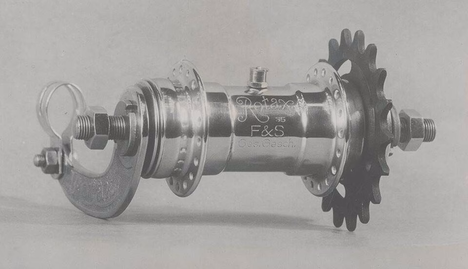 100 Jahre Rotax - Kampagne und Microsite 5 Historische Rotax-Fahrradnabe mit Ritzel aus Metall, detailreich fotografiert als Teil der Rückschau auf 100 Jahre Technik.