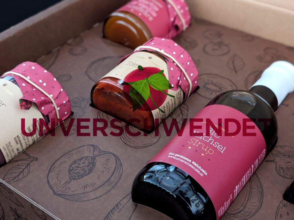 Unverschwendet Performance Marketing 1 Nahaufnahme eines Produktsets von Unverschwendet mit Sirup und Konfitüre aus geretteten Früchten in dekorativer Verpackung.