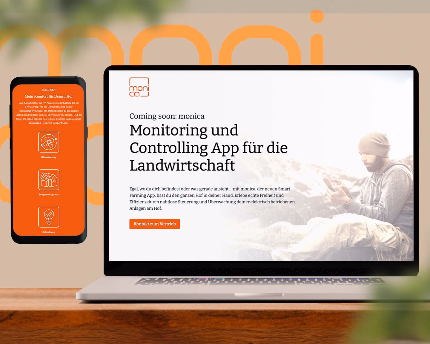 Laptop und Smartphone zeigen Website zur App „monica“ für landwirtschaftliches Monitoring, daneben Mann mit Smartphone auf Wiese.