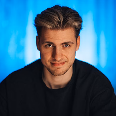 Junger Mann vor blauem Hintergrund.