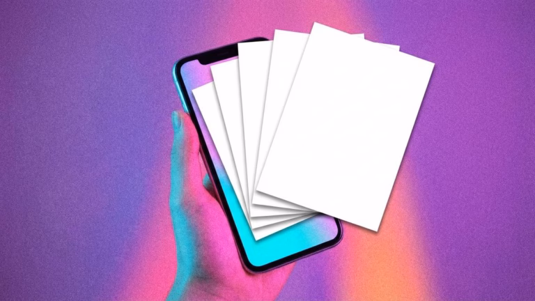 Eine Hand hält ein Smartphone mit weißen Blättern im Hintergrund.